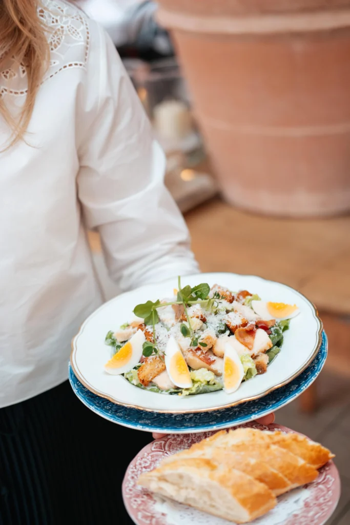 Een rijkgevulde Caesar Salade met knapperige Romeinse sla, parmezaanse kaas en huisgemaakte dressing, een van de populaire brasserie gerechten bij Brasserie Bellevue Eindhoven.